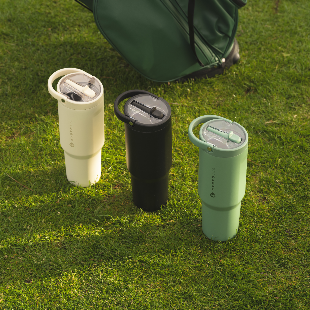 HydroJug Sport Bottles in Cream, Black, and Sage on Grass