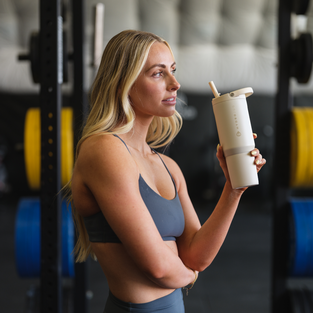 Woman Holding HydroJug Cream Sport Bottle 20oz at Gym